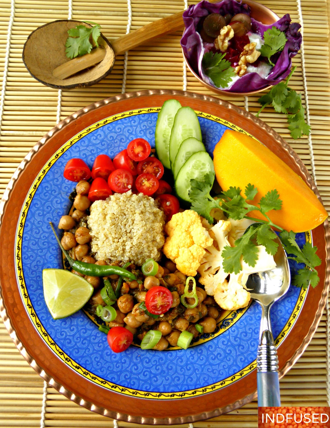 Easy recipe for Indian spiced Buddha Bowl with chana masala, quinoa, veggies, raita and mango
